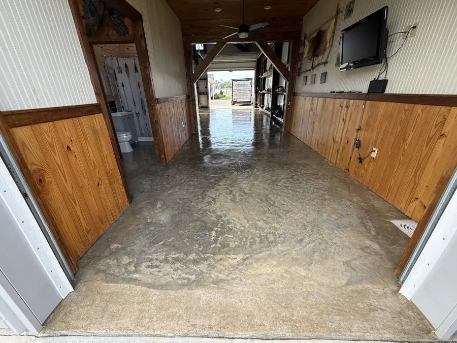 Metallic epoxy floor through a pine-paneled camp hallway