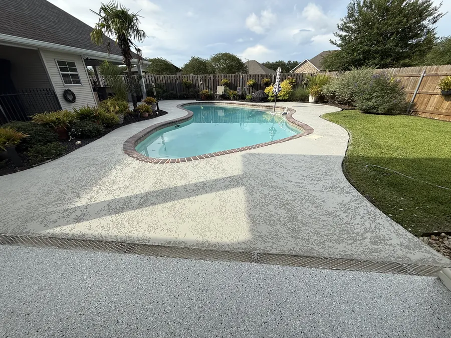 Flake-coated pool deck wrapping a backyard pool in Morgan City, LA