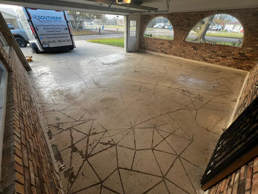 Worn stamped slab in the arched-window garage before coating