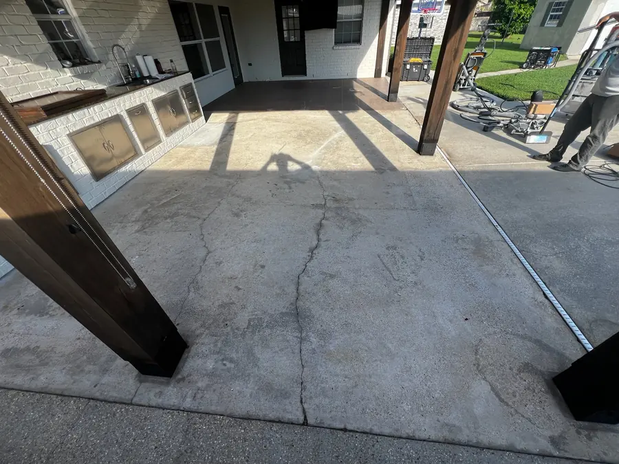 Cracked patio slab beside the pool before coating