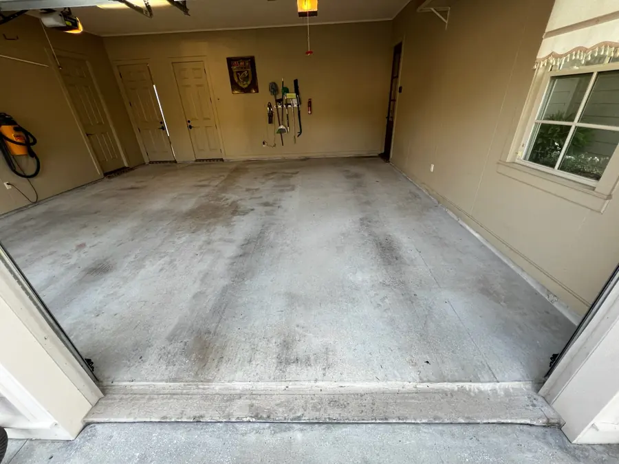 Tan-walled garage slab with oil stains before coating