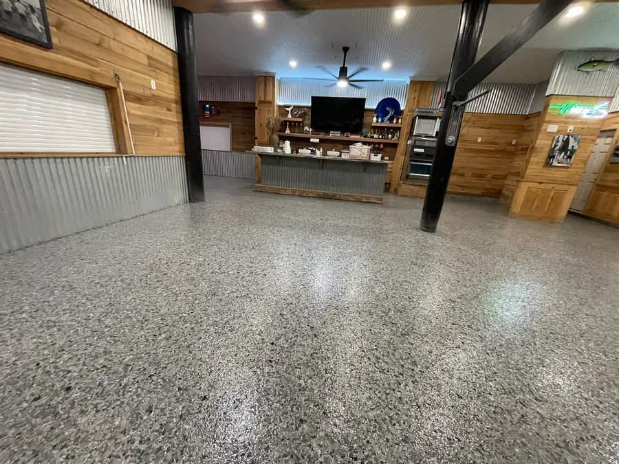 Grey flake floor stretching to the TV wall in a rustic camp