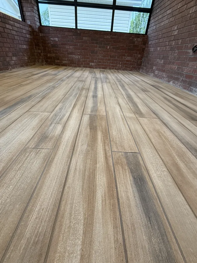 Wood plank concrete overlay in a brick sunroom
