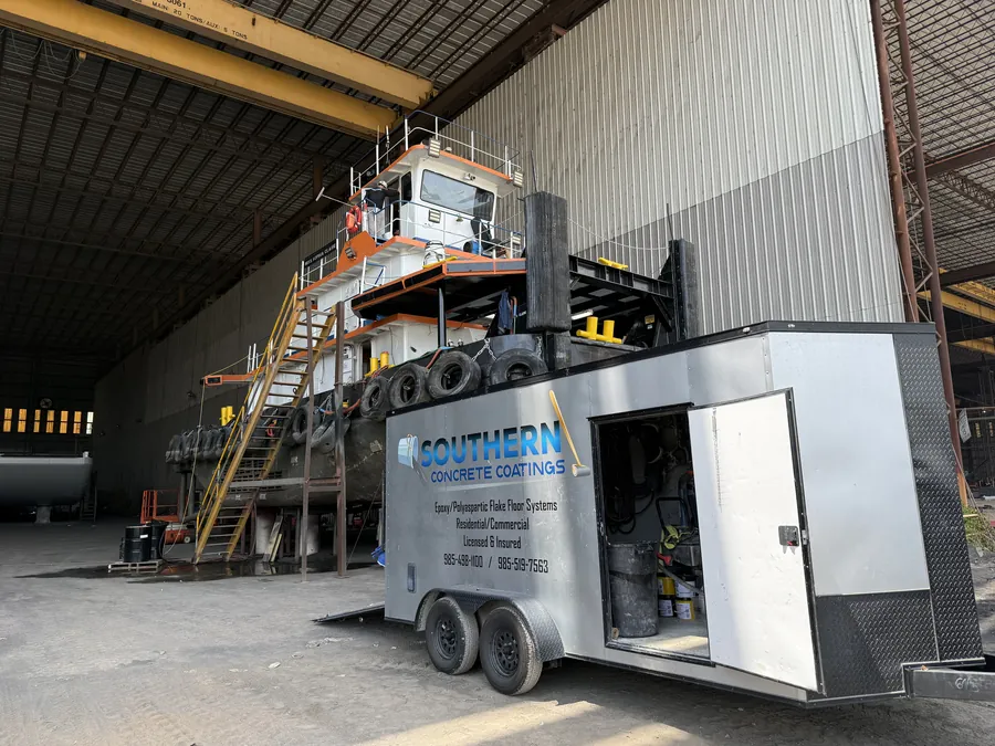 Southern Concrete Coatings trailer staged beside a tugboat in a shipyard