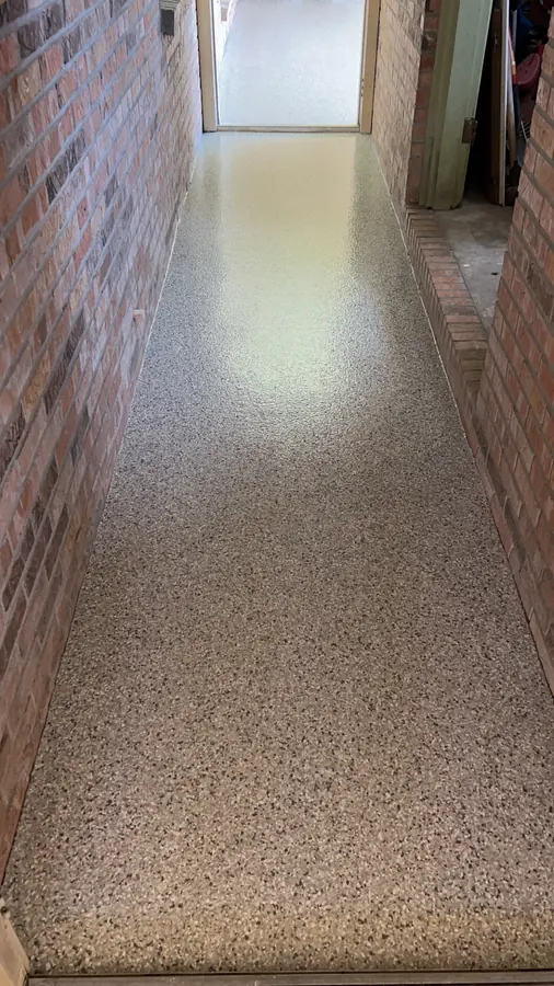 Narrow flake-coated walkway between brick walls