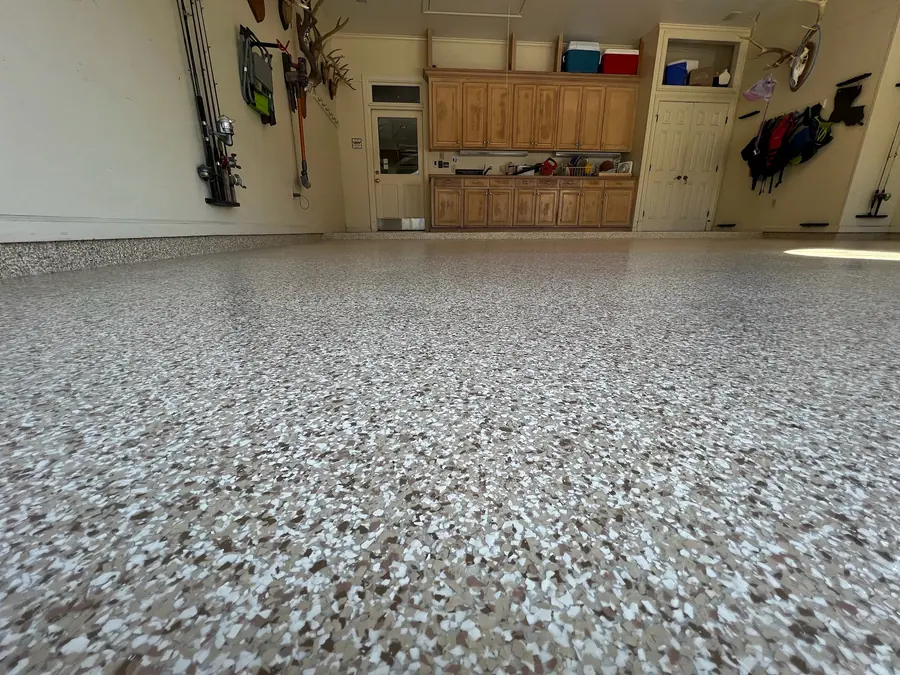 Close-up of a tan flake floor in front of garage cabinets