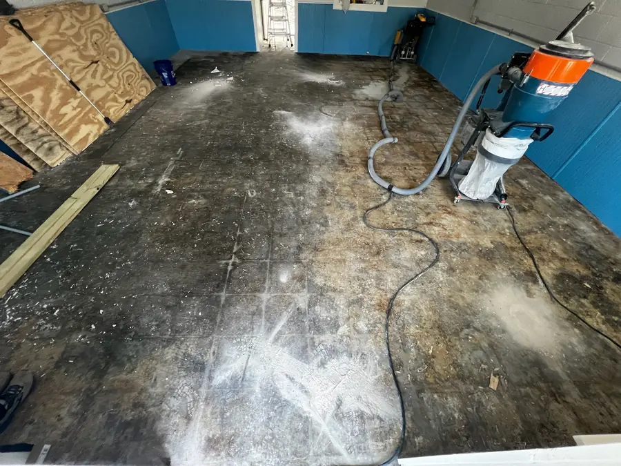 Garage slab being ground and vacuumed before coating