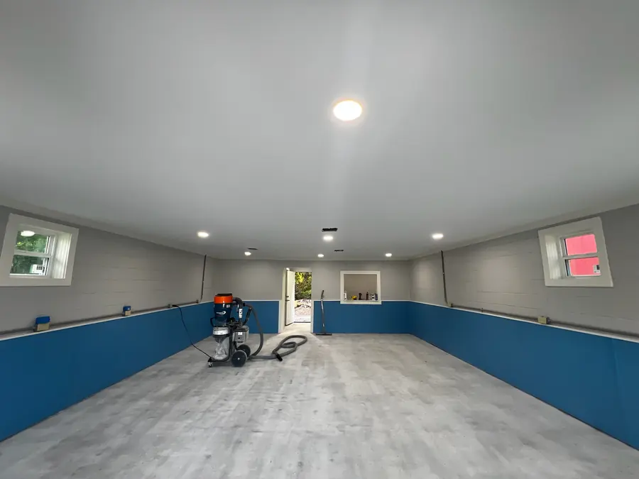 Prepped garage slab with a blue wainscot, ready for coating