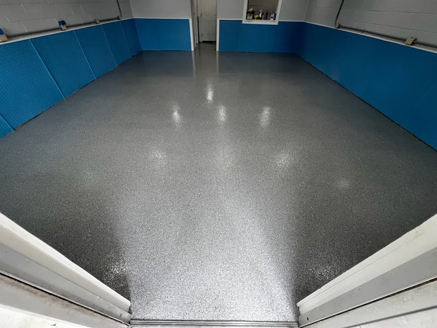 Glossy grey flake floor in a garage with a blue wainscot