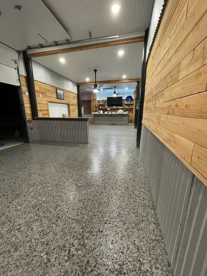 Long view of grey flake flooring past a corrugated tin wainscot