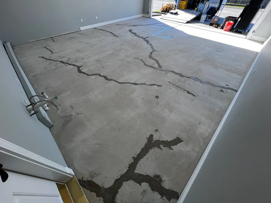 Garage slab with deep cracks before repair and coating